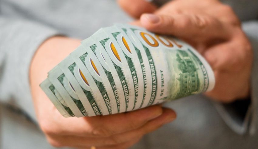 A man is holding a stack of cash in his hands.
