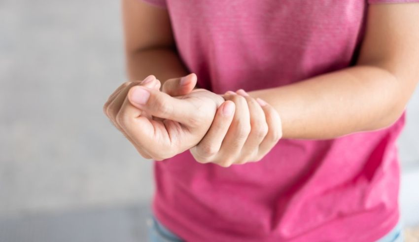 A woman is holding her wrist with pain.