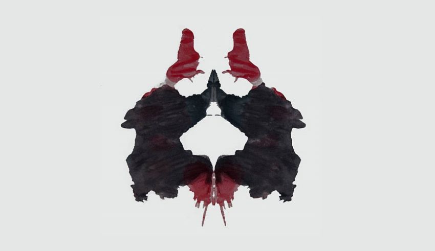 A black and red ink blot on a white background.