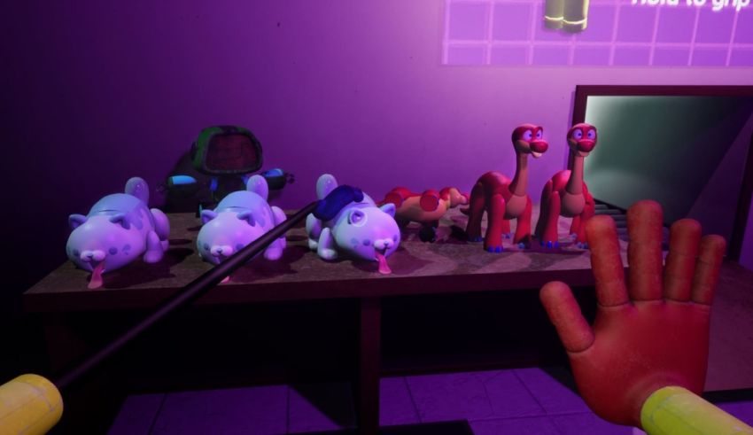 A hand is holding a toy in front of a purple wall.