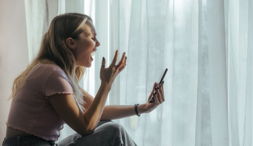 A woman yelling at her phone while sitting on the window sill.