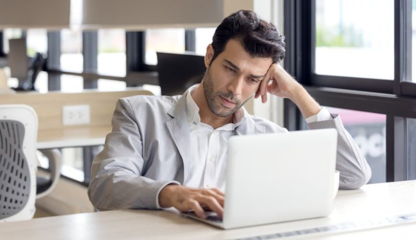 A man working on a laptop in an office.