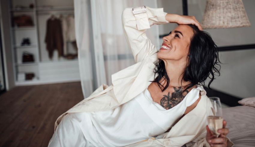 A woman laying on a bed with a glass of wine.