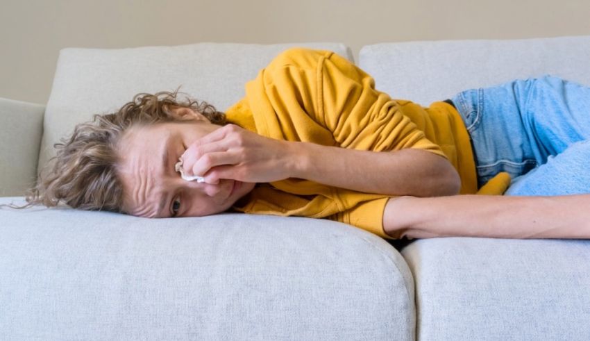 A woman laying on a couch with a cold.