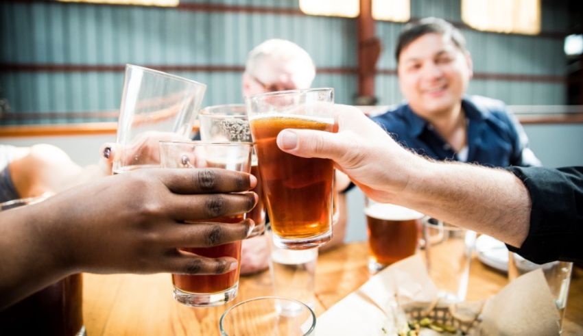 A group of people toasting beer glasses at a table.