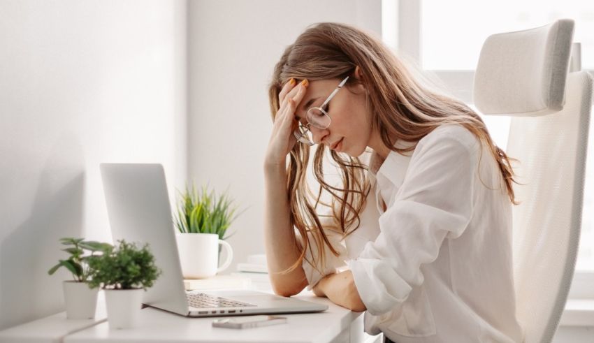 A woman is sitting at her desk with her head on her head.