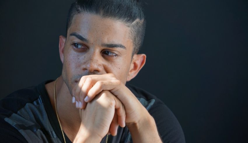 A man with a black shirt and a chin on his hand.