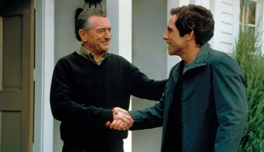 Two men shaking hands in front of a house.
