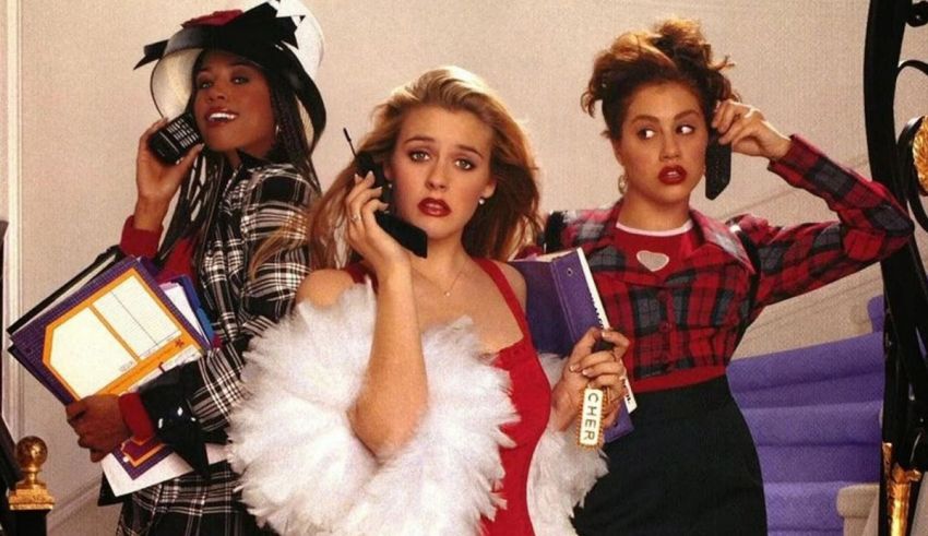 Three women talking on their cell phones in front of a staircase.