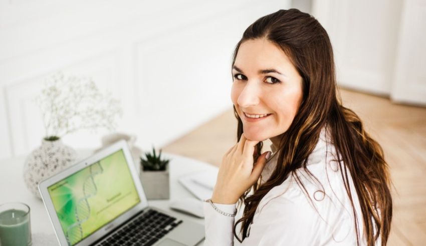 A woman sitting at a desk with a laptop in front of her.
