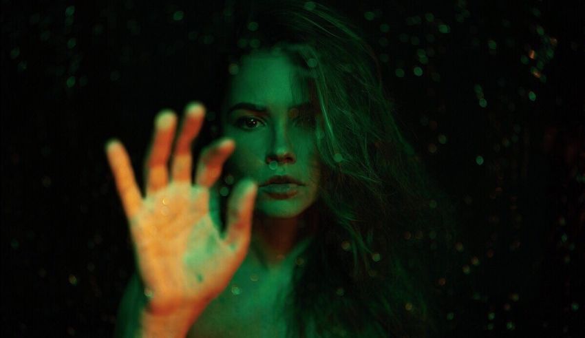 A woman with her hand out in the dark.
