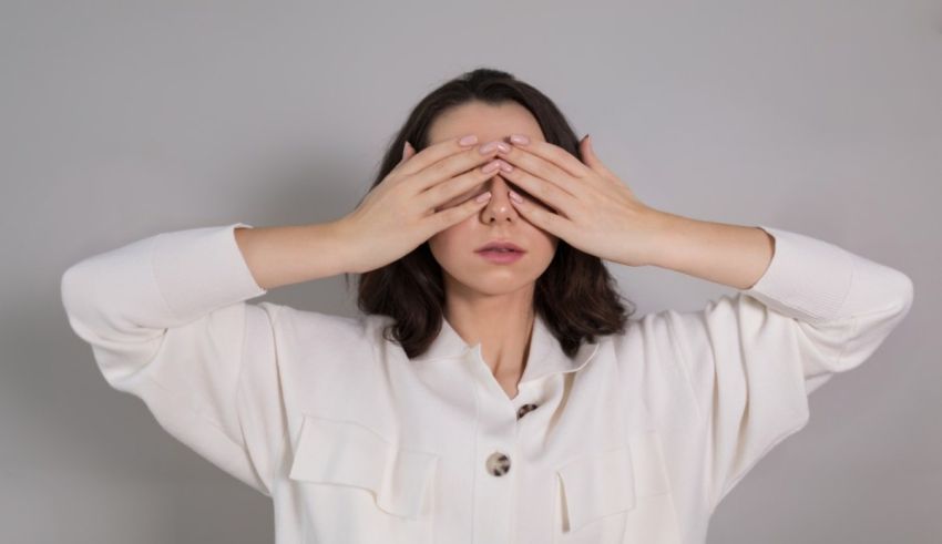 A woman covering her eyes with her hands.