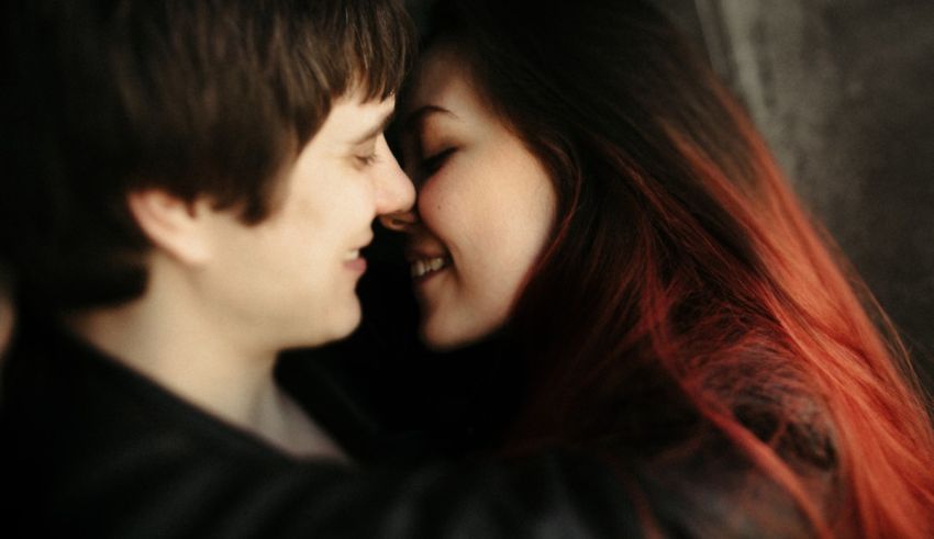 A man and woman hugging each other with red hair.