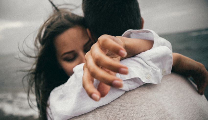 A man is hugging a woman on the beach.