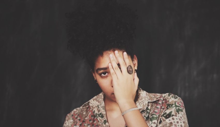A woman covering her face with her hands.
