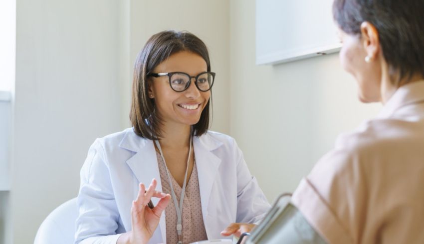 A woman is talking to a doctor in a doctor's office.