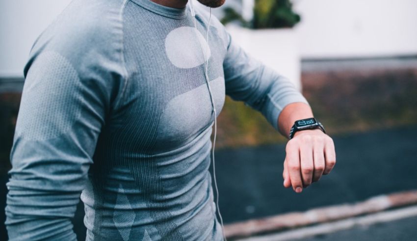 A man wearing a smart watch while walking down the street.