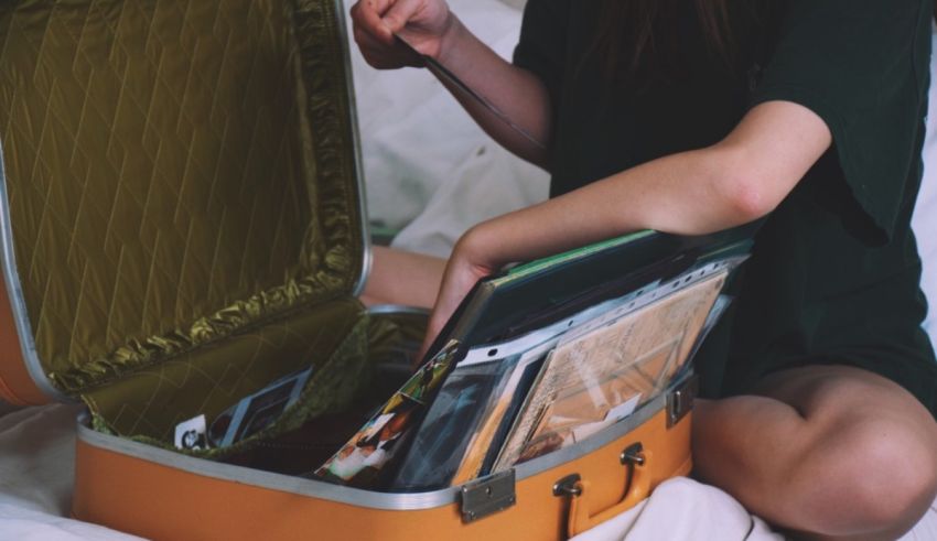 A woman is opening a suitcase on a bed.