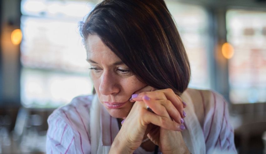 A woman sitting in a restaurant looking sad.