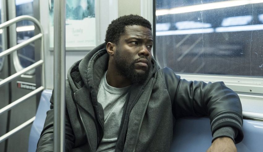 A black man sitting on a subway train.
