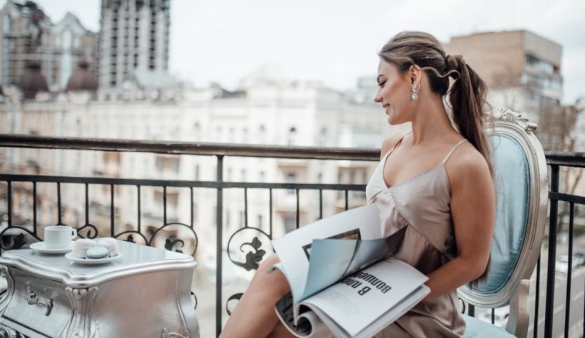 A woman sitting on a balcony reading a book.
