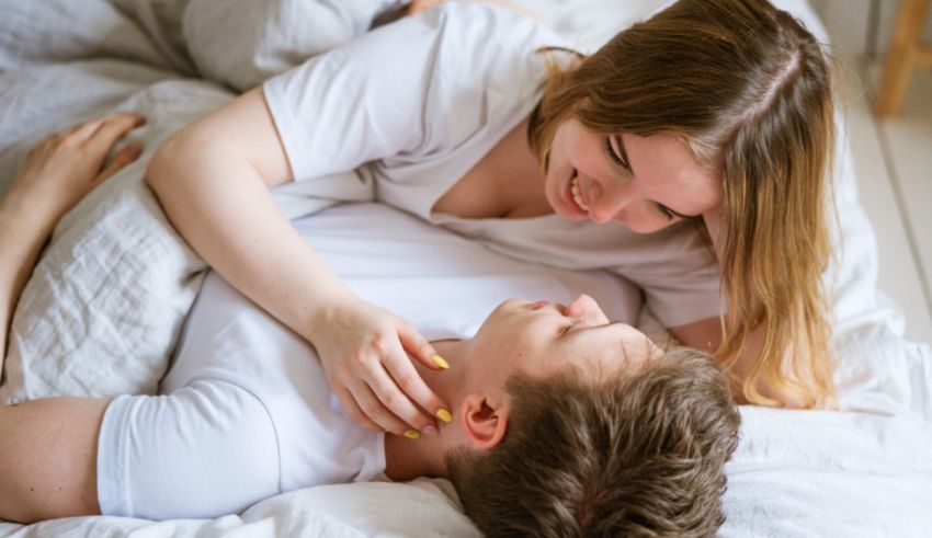 A man and woman are laying in bed together.