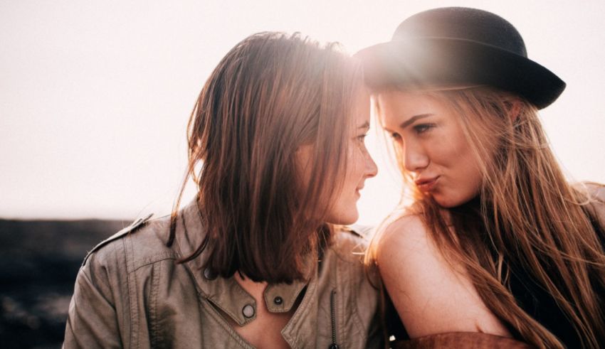 Two women in hats are looking at each other.
