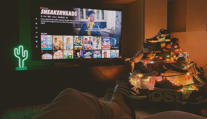 A person is sitting in front of a tv with a christmas tree in front of it.