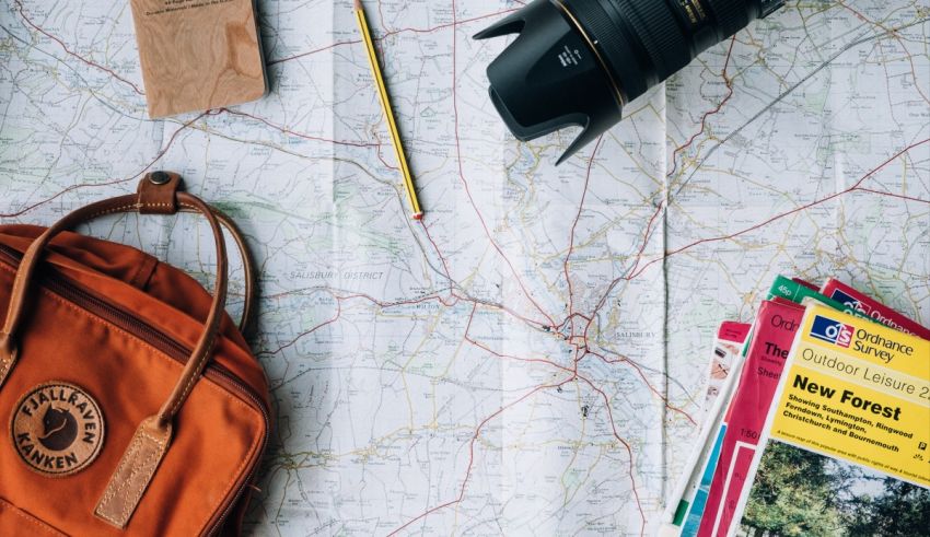 A backpack, camera, map and other items on a map.