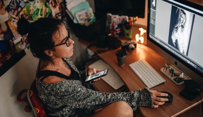 A woman using a computer in front of a desk.