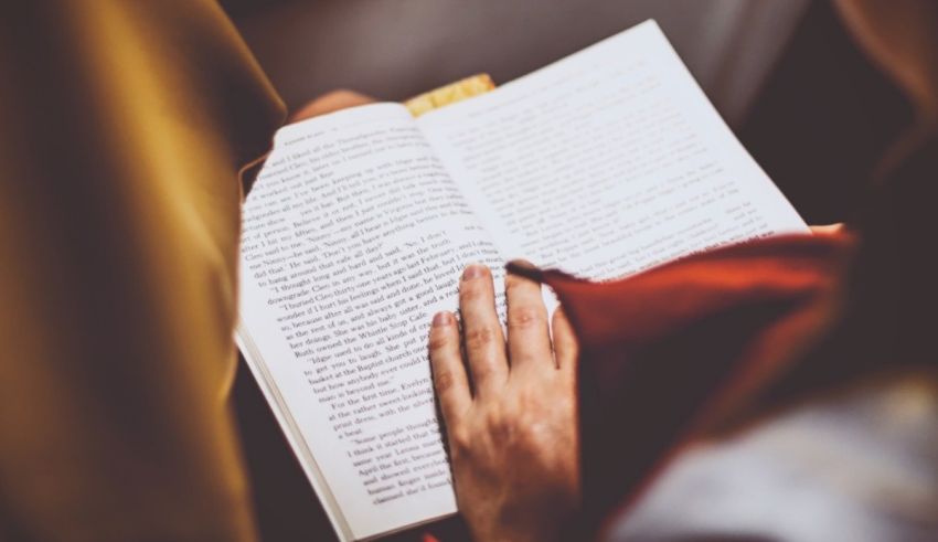 A woman is holding an open book and reading it.