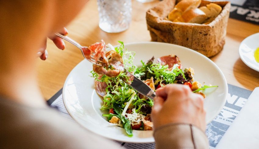 A woman is eating a salad at a table.