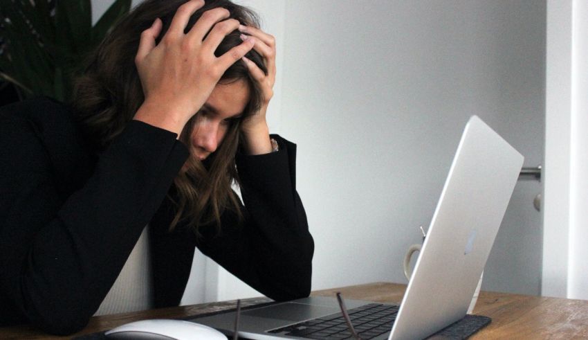 A woman is sitting at a desk with a laptop.