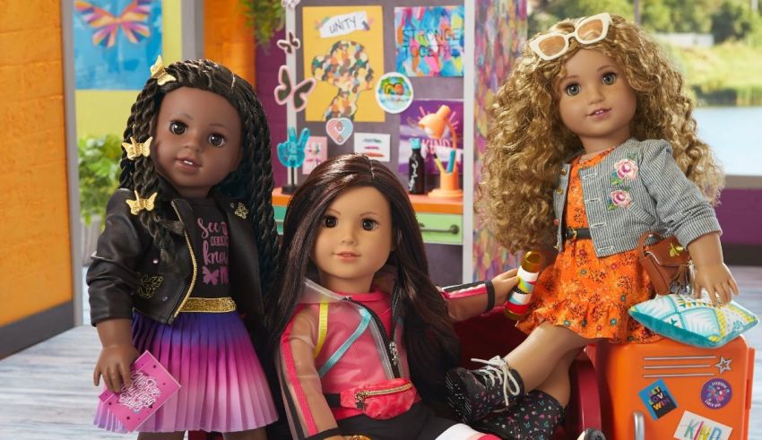 Three american girl dolls are sitting in a room with luggage.