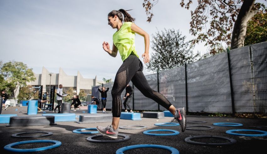 A woman is running around a set of rings.