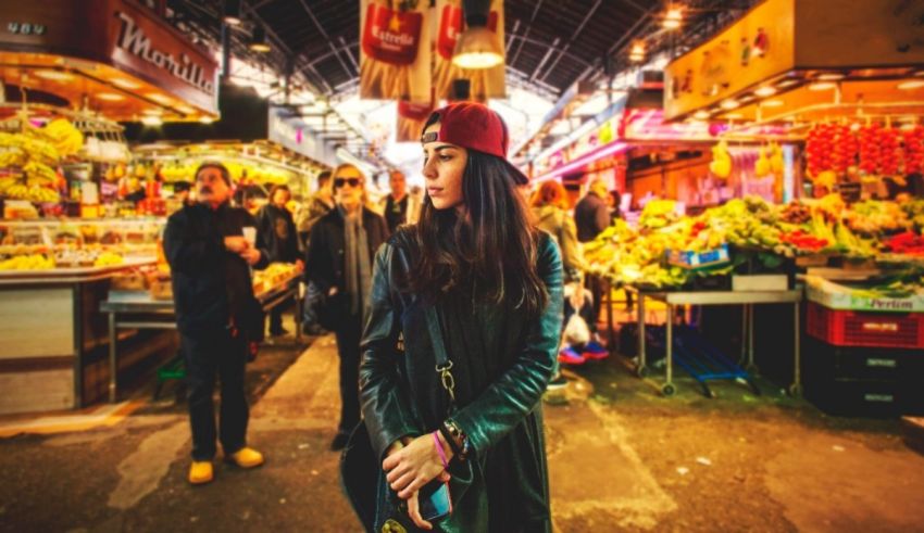 A woman in a black jacket standing in a market.