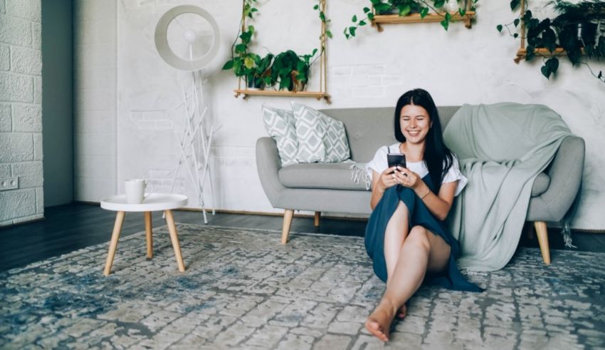Asian woman sitting on the floor and using her phone.