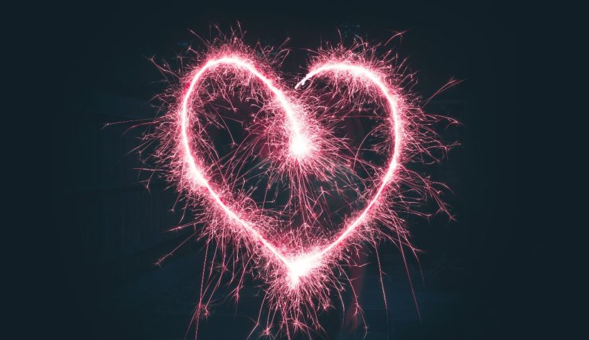 A heart shaped sparkler on a dark background.