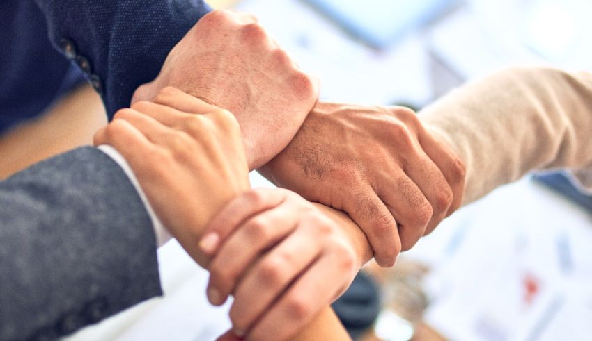 A group of business people putting their hands together.