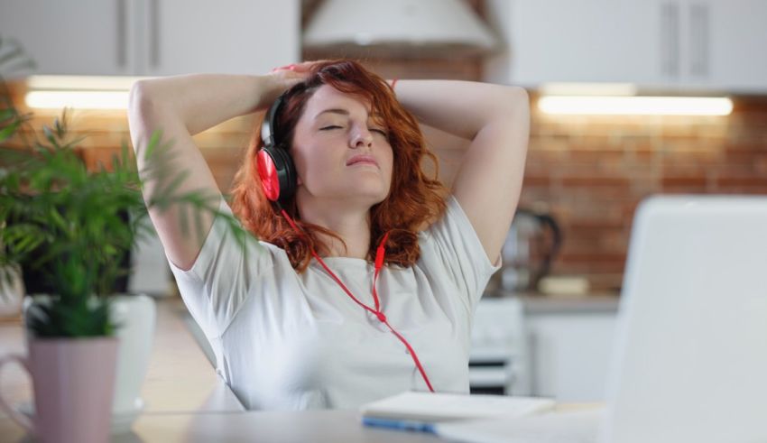 A woman wearing headphones in front of a laptop.