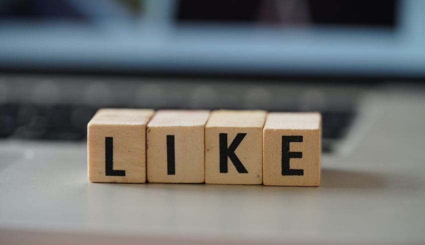 A wooden block with the word like on it sits on top of a laptop.