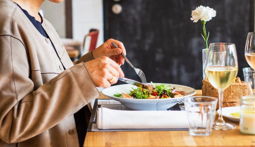 A woman is eating a salad at a restaurant.