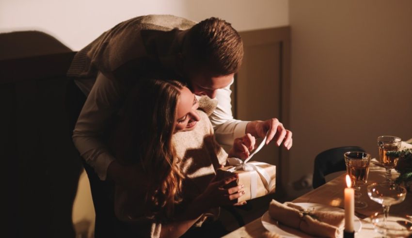A man and woman are sitting at a table with a candle.