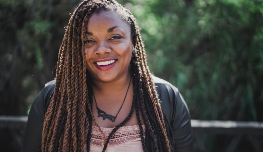 A woman with long braids smiling for the camera.