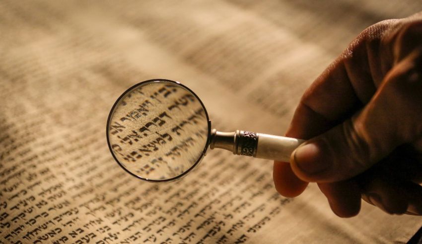 A person is holding a magnifying glass over a book.