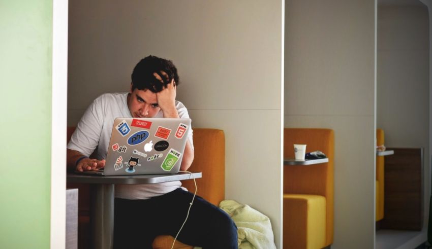 A man sitting at a table with a laptop.