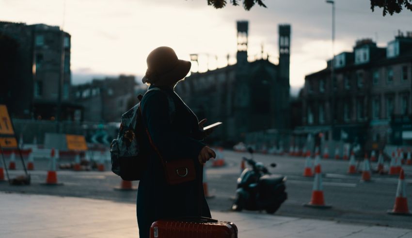 A woman holding a suitcase on a city street.