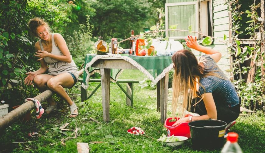 Two women sitting at a table in a backyard.