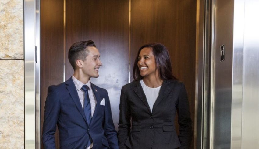Two business people standing in an elevator.