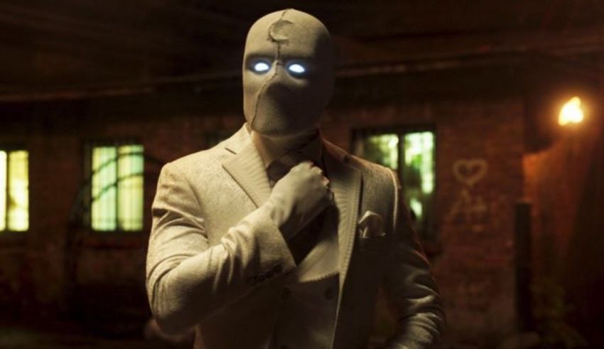 A man in a suit and mask standing in an alley.
